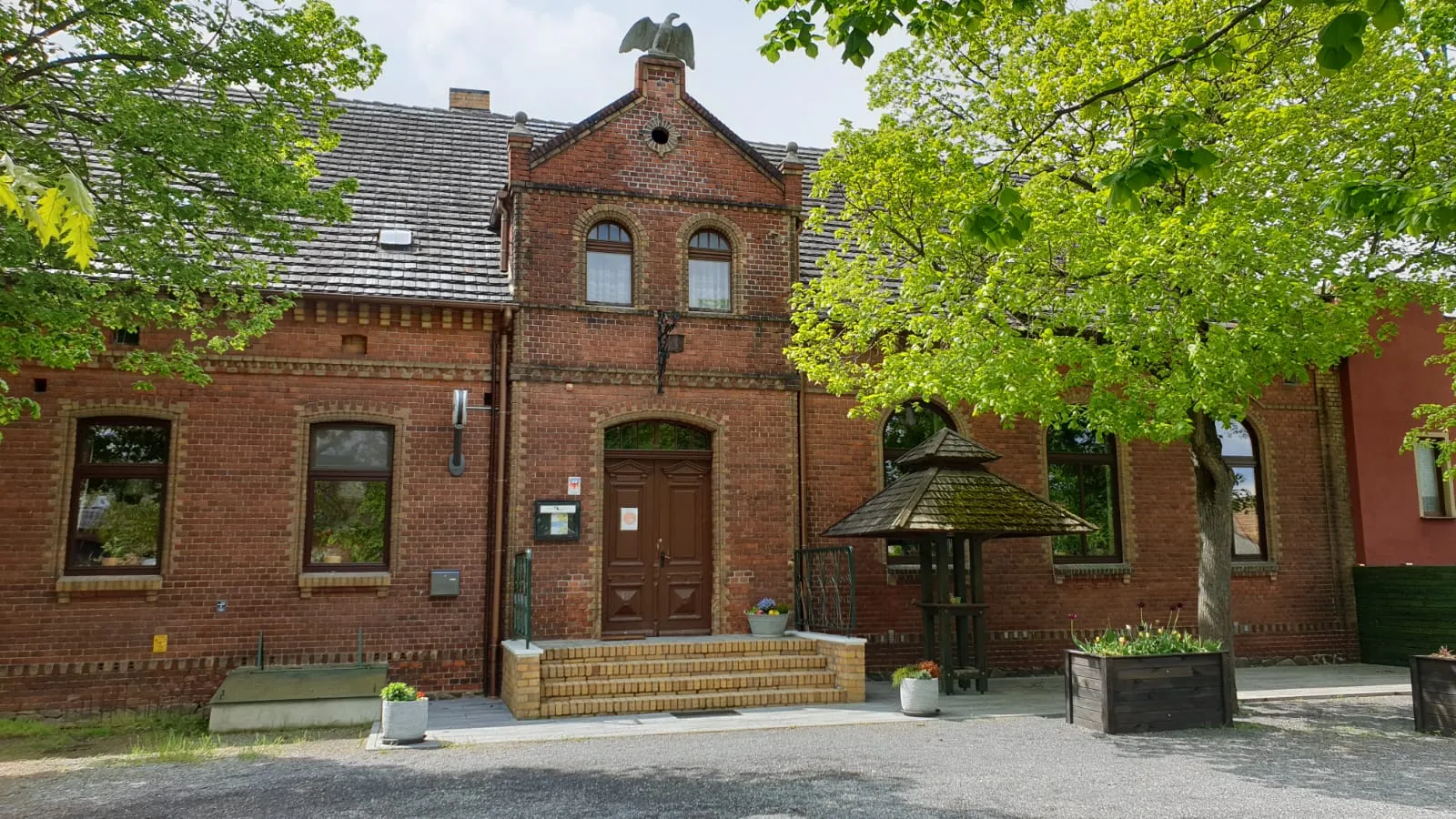 Backsteingebäude des Lindenkrug Großbahren mit Linden vor dem Eingang